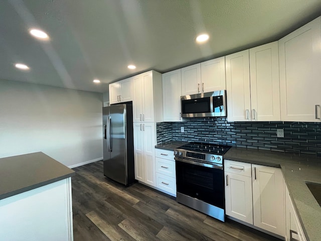 kitchen featuring white cabinetry, stainless steel appliances, dark hardwood / wood-style floors, and tasteful backsplash