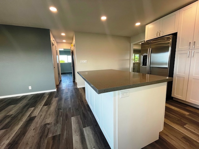 kitchen featuring white cabinetry, dark wood-type flooring, a center island, and stainless steel fridge