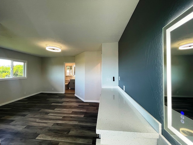 unfurnished room with a textured ceiling and dark hardwood / wood-style flooring