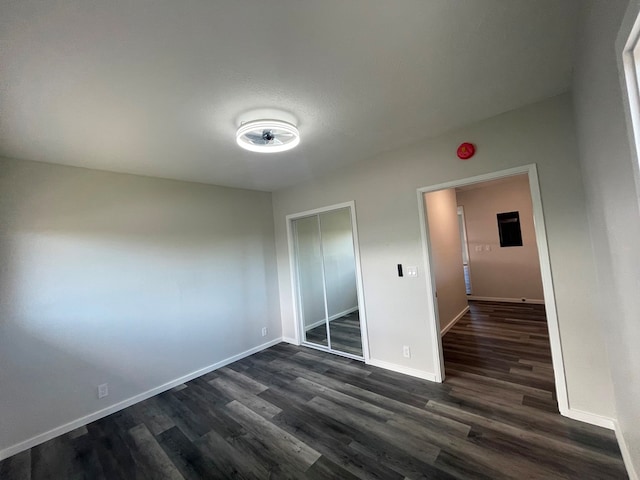 unfurnished bedroom with a closet and dark hardwood / wood-style flooring