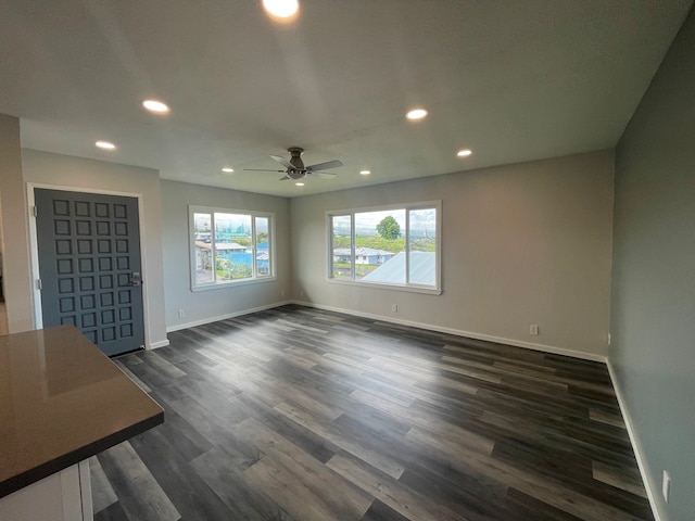 unfurnished living room with dark wood-type flooring and ceiling fan