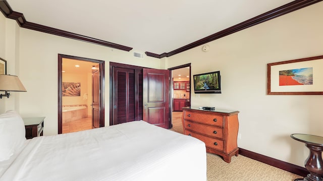 carpeted bedroom with a closet, ornamental molding, and connected bathroom