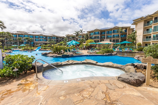 view of pool featuring pool water feature and a community hot tub