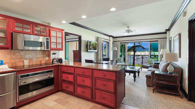 kitchen featuring kitchen peninsula, backsplash, ornamental molding, appliances with stainless steel finishes, and ceiling fan