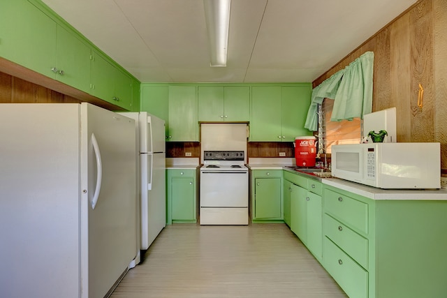 kitchen featuring sink, light hardwood / wood-style flooring, green cabinets, and white appliances