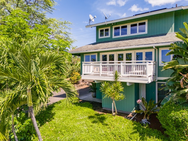 back of house with a wooden deck and a lawn