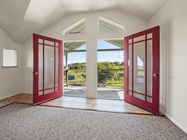 foyer with french doors, light tile patterned floors, and vaulted ceiling