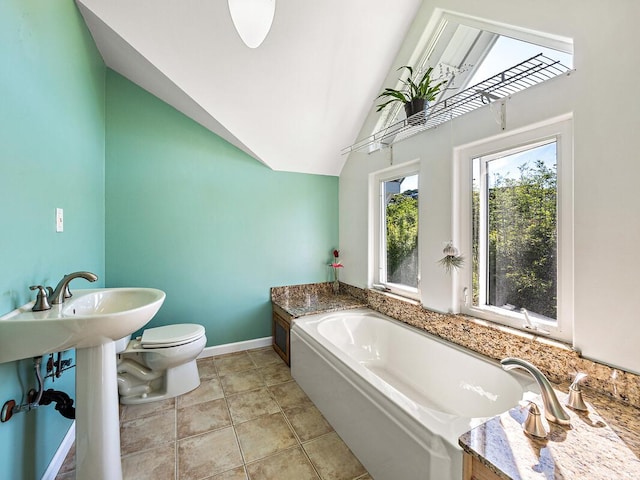 bathroom featuring tile patterned floors, toilet, a tub to relax in, and vaulted ceiling