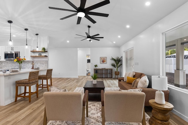 living room featuring ceiling fan and light hardwood / wood-style flooring