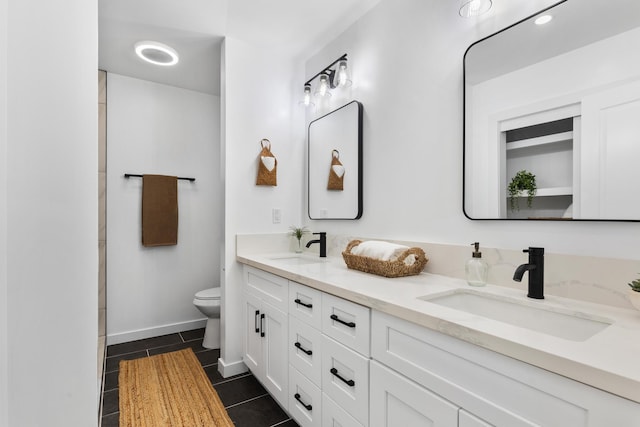 bathroom with toilet, vanity, and tile patterned floors