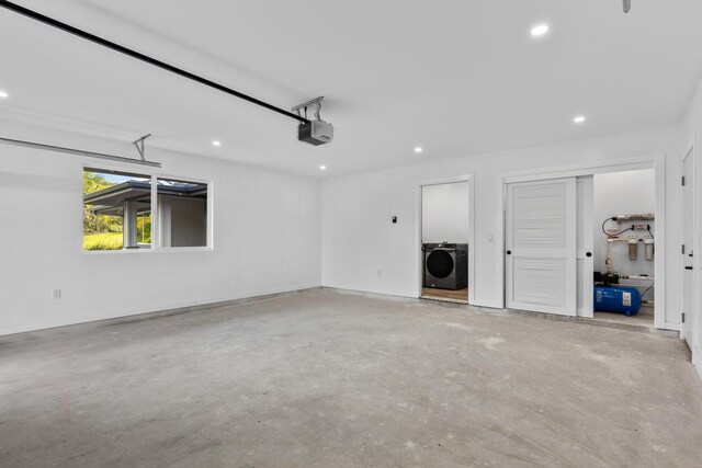 garage with a garage door opener and washer / dryer