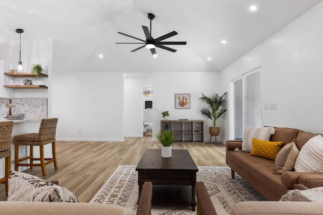 living room with ceiling fan, light hardwood / wood-style floors, and lofted ceiling