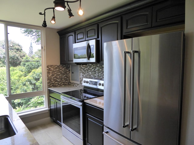 3811 Edward Rd Unit 1202, Princeville, HI 96722 - kitchen featuring appliances with stainless steel finishes, tasteful backsplash, light tile patterned flooring, and light stone counters