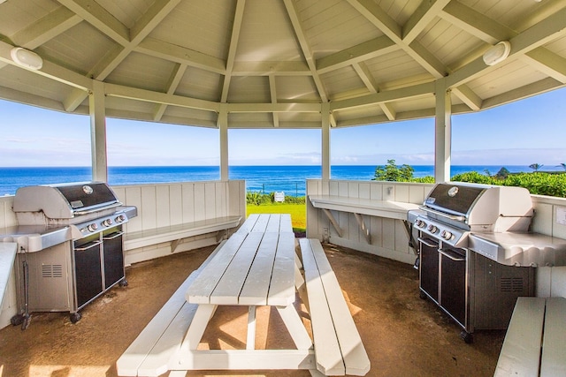 view of patio featuring a gazebo, exterior kitchen, a water view, and grilling area