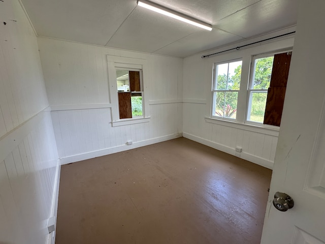 empty room with wooden walls and concrete floors