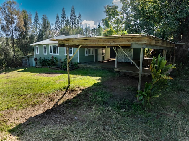 rear view of house featuring a yard and a carport