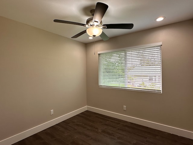 spare room with dark wood-type flooring and ceiling fan