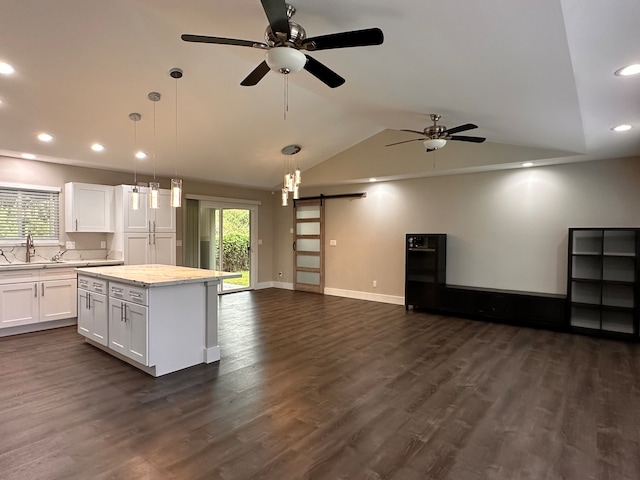 kitchen featuring white cabinets, a barn door, a center island, and a healthy amount of sunlight