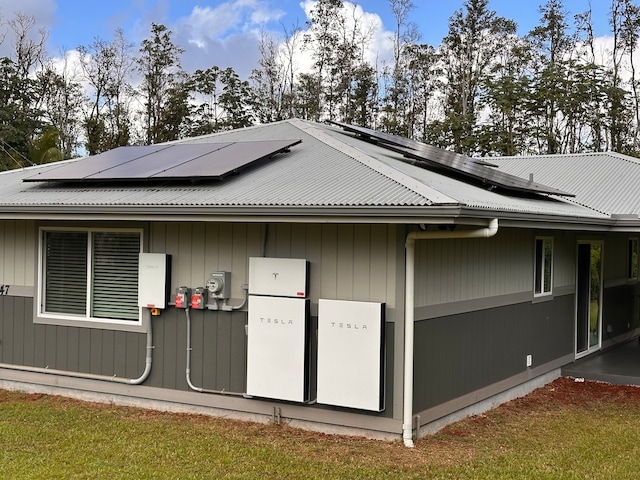 view of property exterior featuring a lawn and solar panels