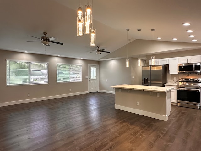 kitchen featuring dark hardwood / wood-style floors, stainless steel appliances, vaulted ceiling, pendant lighting, and white cabinetry