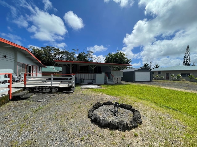 view of front of home with a garage, a front lawn, and an outbuilding