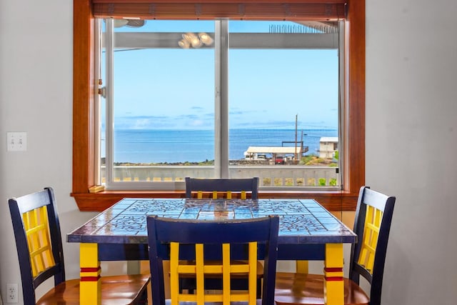 dining area with a wealth of natural light and a water view