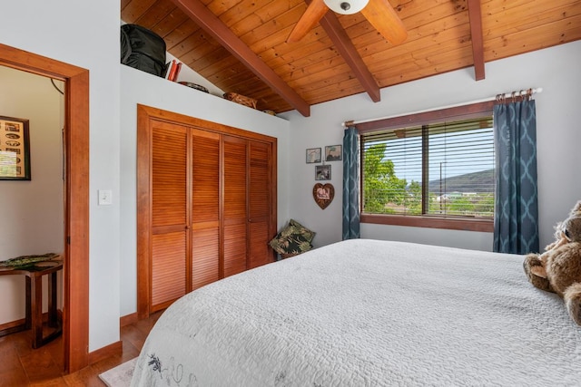 bedroom featuring wood ceiling, hardwood / wood-style floors, ceiling fan, vaulted ceiling with beams, and a closet