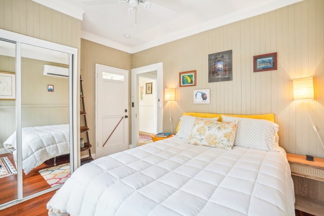 bedroom with ceiling fan, hardwood / wood-style flooring, a wall mounted air conditioner, wood walls, and a closet