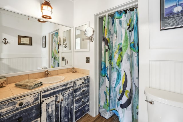 bathroom with toilet, vanity, and wood-type flooring