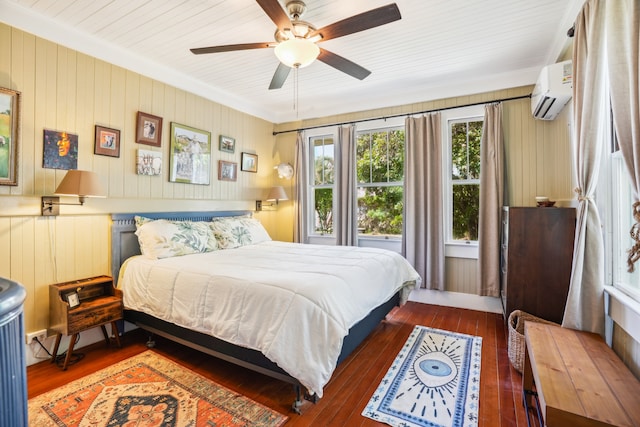 bedroom with dark hardwood / wood-style floors, an AC wall unit, crown molding, ceiling fan, and wood walls