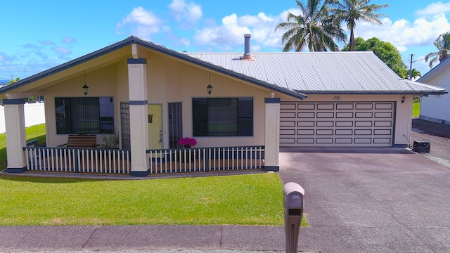 view of front of house with a front lawn, metal roof, driveway, and an attached garage