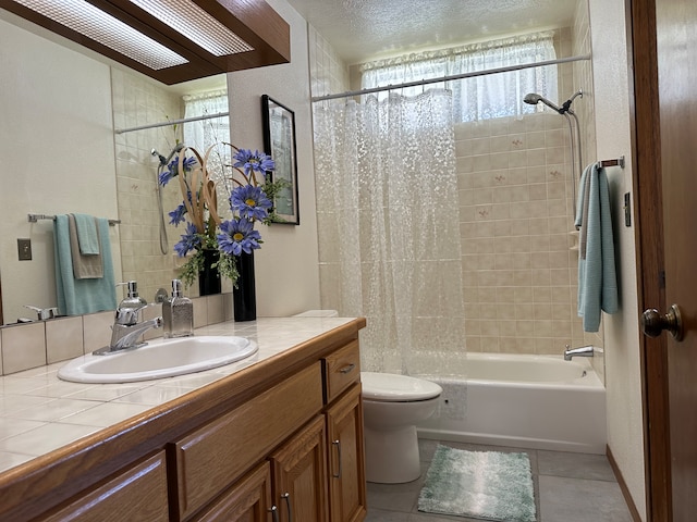 full bathroom featuring tile patterned floors, toilet, vanity, a textured ceiling, and shower / bathtub combination with curtain