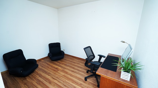 office space featuring baseboards and wood finished floors