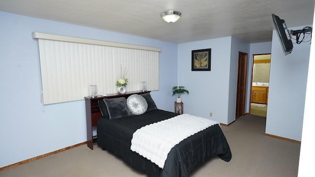 carpeted bedroom with connected bathroom and a textured ceiling