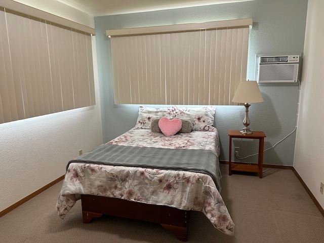 bedroom featuring a textured wall, carpet floors, a wall mounted AC, and baseboards