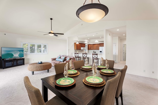 carpeted dining space with vaulted ceiling and ceiling fan