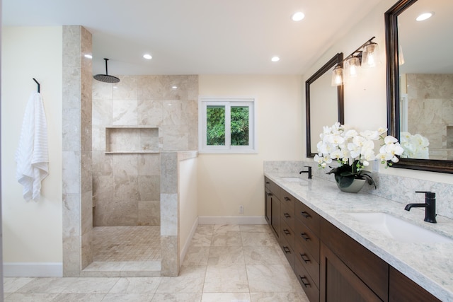 bathroom featuring a tile shower and vanity