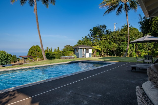 view of pool with a yard and an outdoor structure