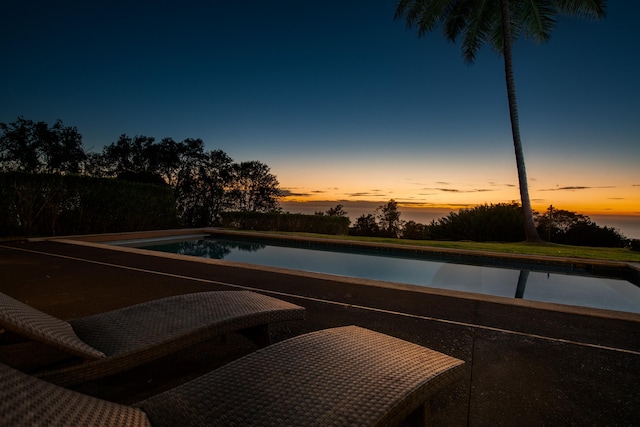 view of pool at dusk