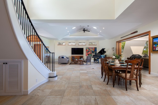 dining space with a raised ceiling and ceiling fan