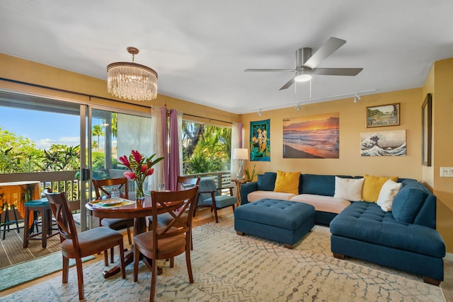 dining space featuring ceiling fan with notable chandelier and light wood-type flooring