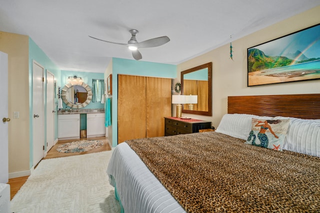 bedroom featuring connected bathroom, light hardwood / wood-style floors, and ceiling fan