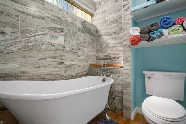 bathroom featuring toilet, tile walls, hardwood / wood-style floors, and a washtub