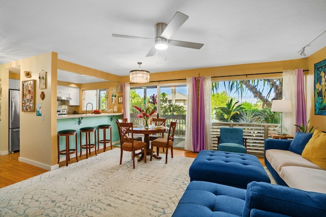 living room with sink, light hardwood / wood-style flooring, and ceiling fan