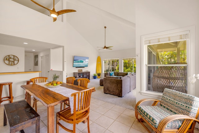 dining space featuring light colored carpet, beamed ceiling, high vaulted ceiling, and ceiling fan