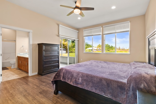 bedroom with hardwood / wood-style flooring, ceiling fan, and ensuite bath