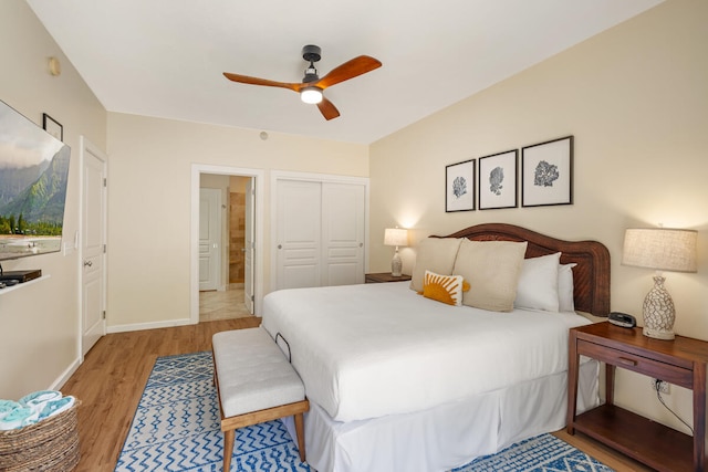 bedroom with light hardwood / wood-style floors, ceiling fan, and a closet