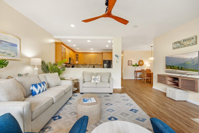 living room with light wood-type flooring and ceiling fan