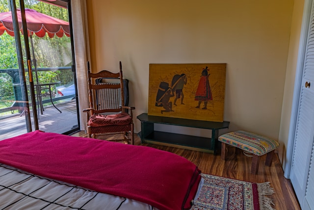 bedroom featuring hardwood / wood-style floors, multiple windows, and access to exterior