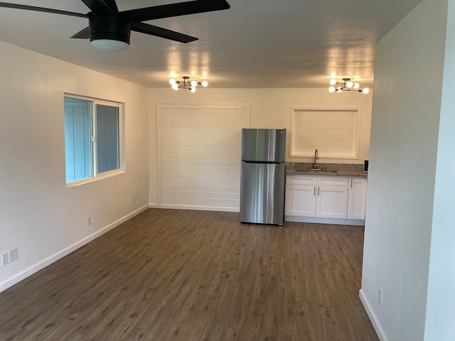 unfurnished living room featuring dark hardwood / wood-style floors, sink, and ceiling fan